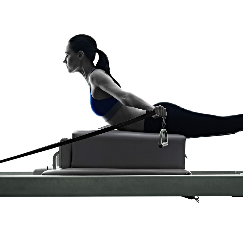 one caucasian woman exercising pilates reformer exercises fitness in silhouette isolated on white backgound